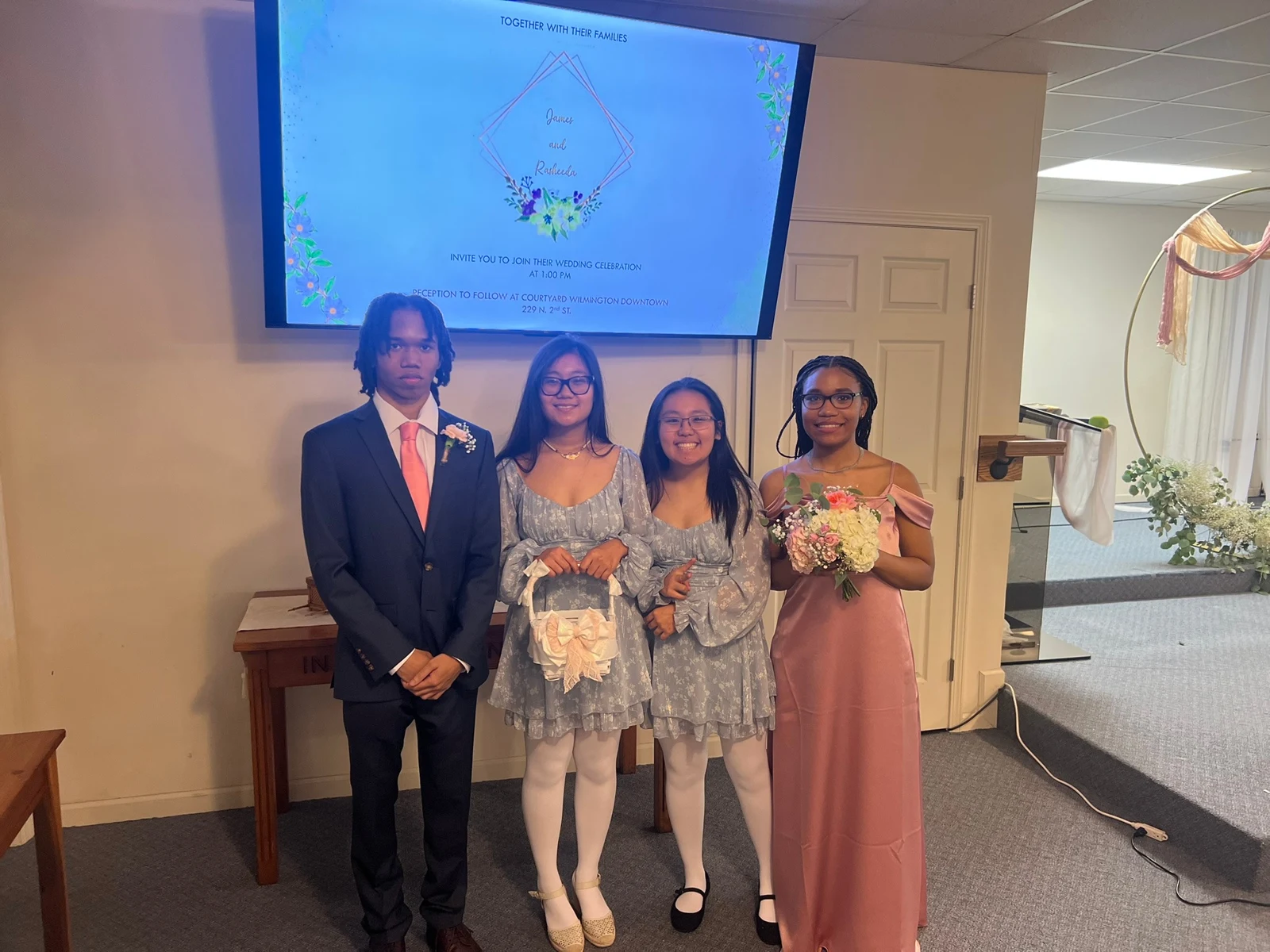 Four people posing together in formal attire inside the church